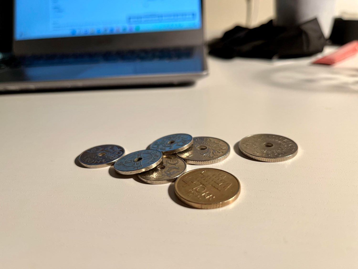 Norske mynter ligger p&aring; et skrivebord 