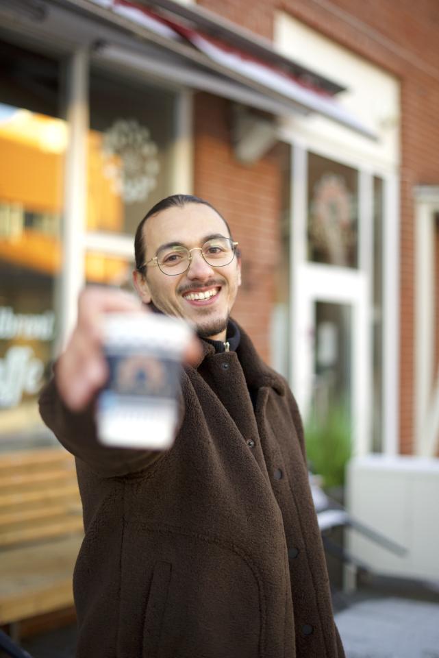 Yassin El Barkani skåler med kaffekoppen sin utenfor Kulturkaféen på Holmlia.