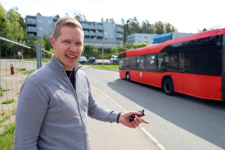 Morten Punnerud st&aring;r ved veien og en buss kj&oslash;rer forbi.