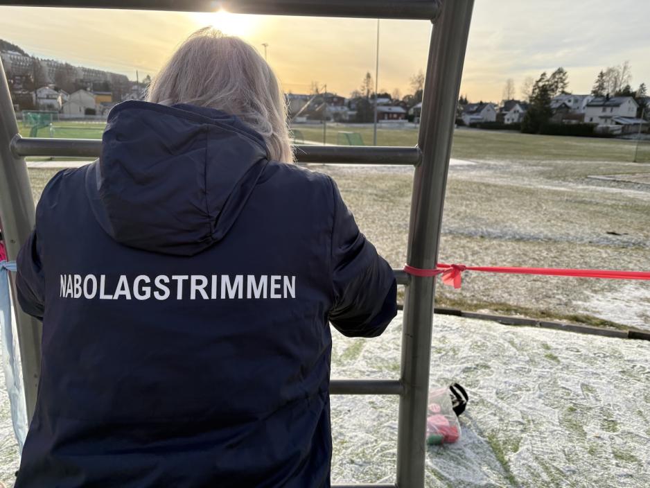 Kvinne st&aring;r med treningsapparat