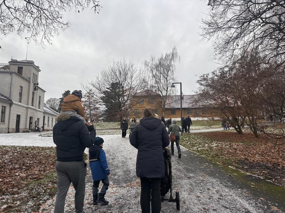 En familie p&aring; vei opp bakken mot bodene i Botanisk hage