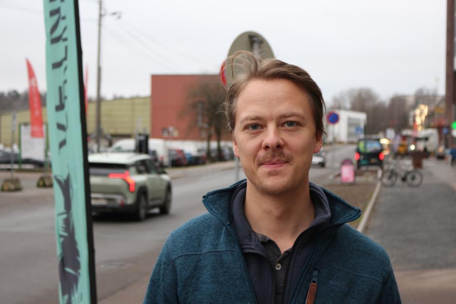 Mann st&aring;r foran veien og ser inn i linsen