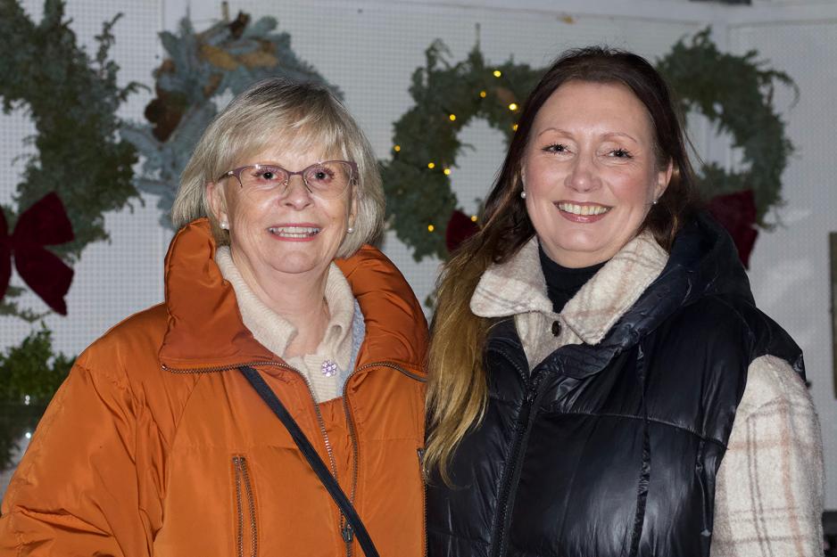 Therese Lunde og Ruth Moe st&aring;r foran julemarkedet.