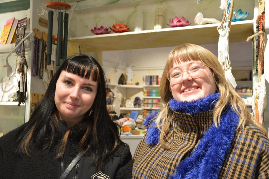 To jenter som smiler til kamera i en krystallbutikk 