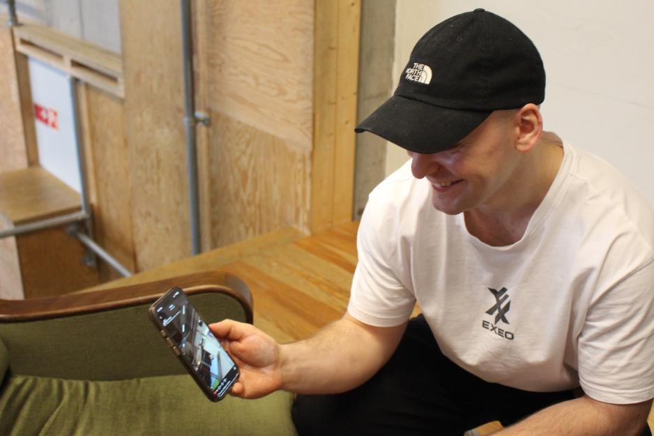 Christian Hansen viser frem en av utøverne sine på telefonen.