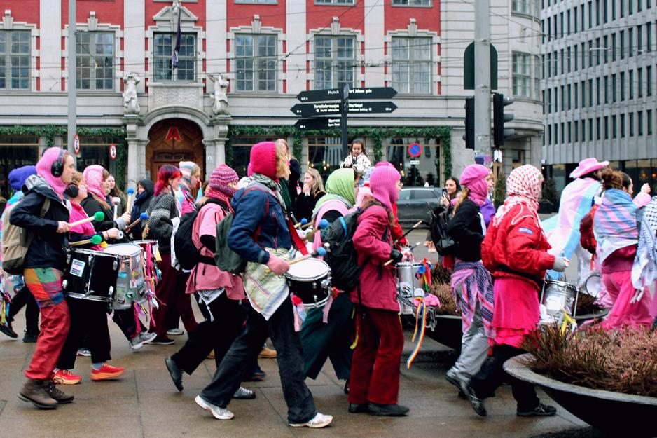 Korpset fra det inkluderende 8. mars toget går forbi ikledd alle regnbuens farger
