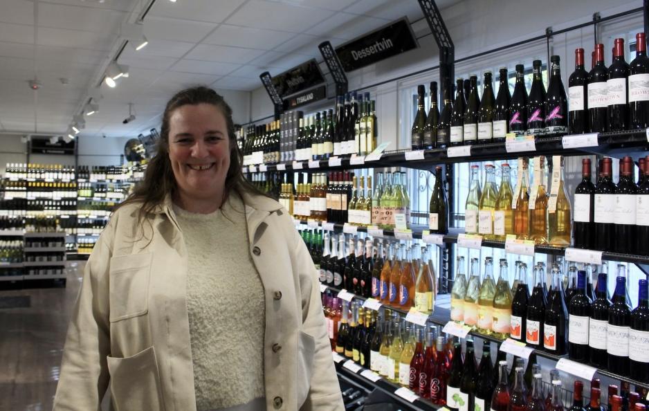 Anne Engrav foran hyllene på vinmonopolet