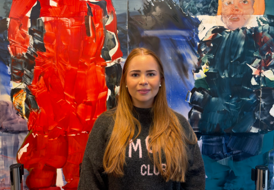 Anna står foran et maleri på OsloMet 