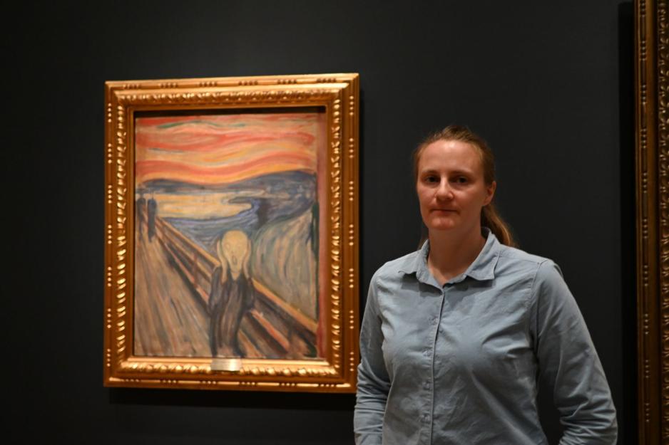 Pia Berggård som poserer foran Skrik-maleriet inne på Nasjonalmuseet