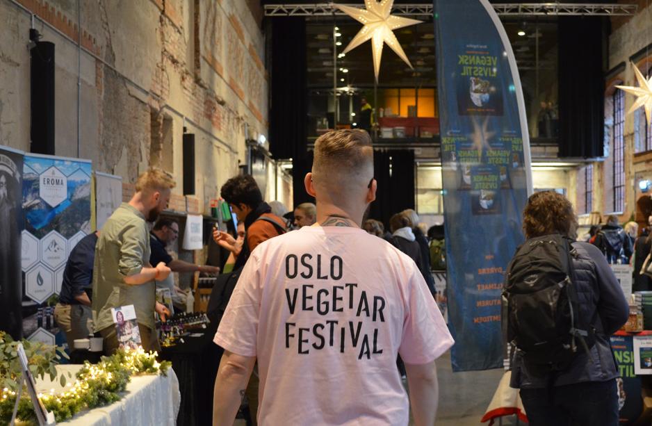 mann i rosa genser g&aring;r med en t-skjorte hvor det st&aring;r Oslo Vegetarfestival.