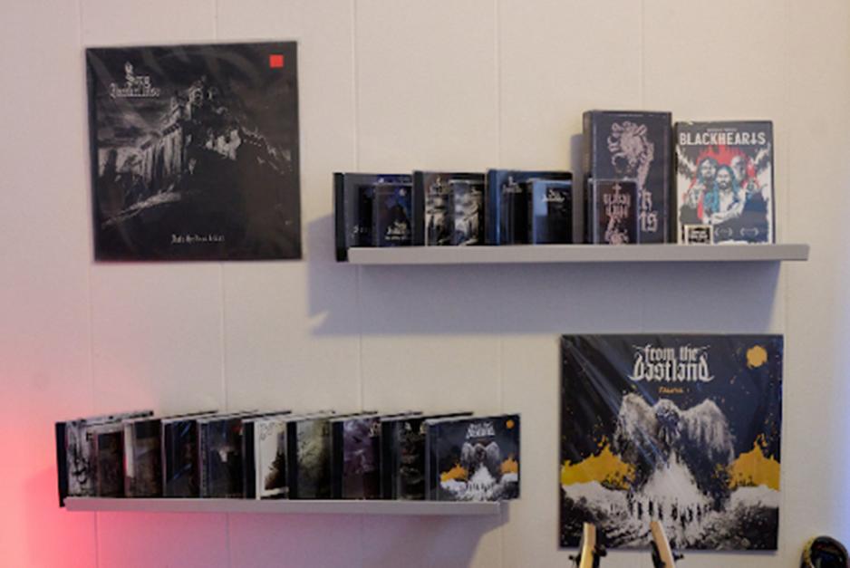 En samling av CD'er og plater p&aring; en vegg montert hylle. 