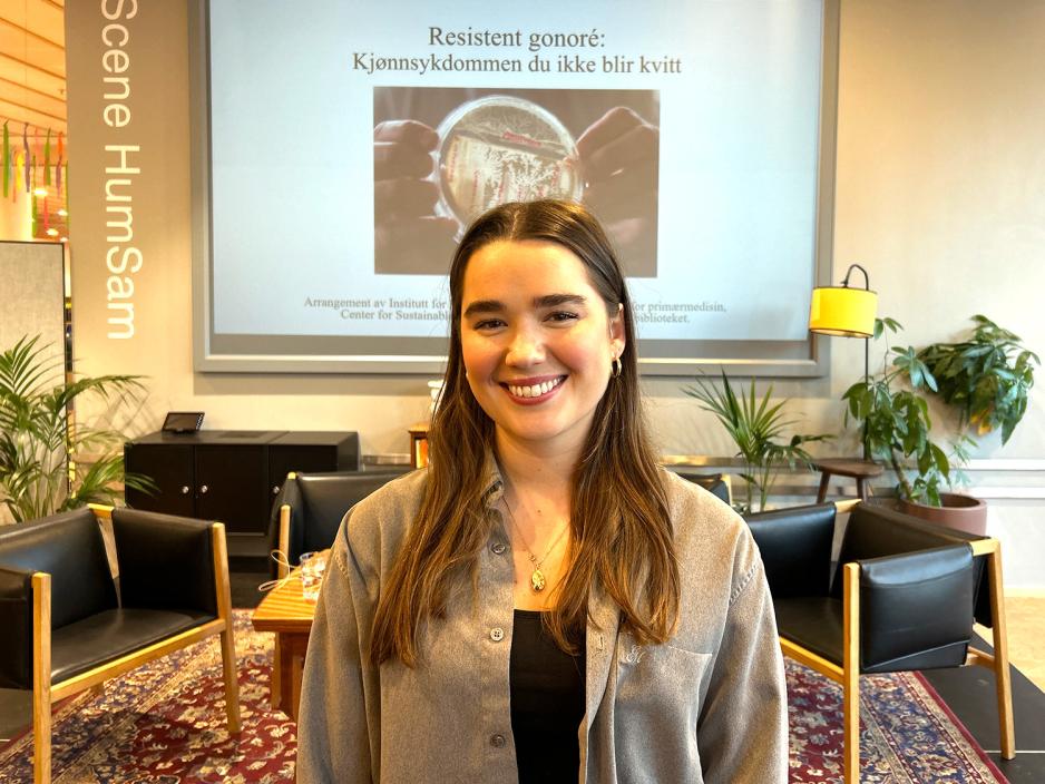 Amanda hylland Spjeldnaes foran presentasjon av arrangement om antibiotikaresistent gonor&eacute;