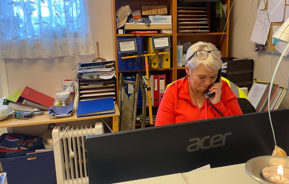 En eldre dame sitter &aring; snakker med noen over fasttelefon.