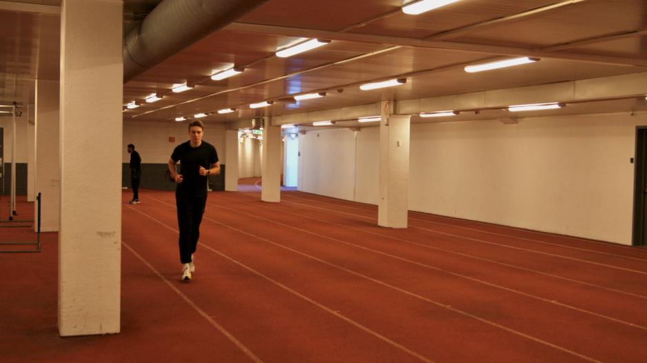 Mann jogger p&aring; r&oslash;dt tartandekke