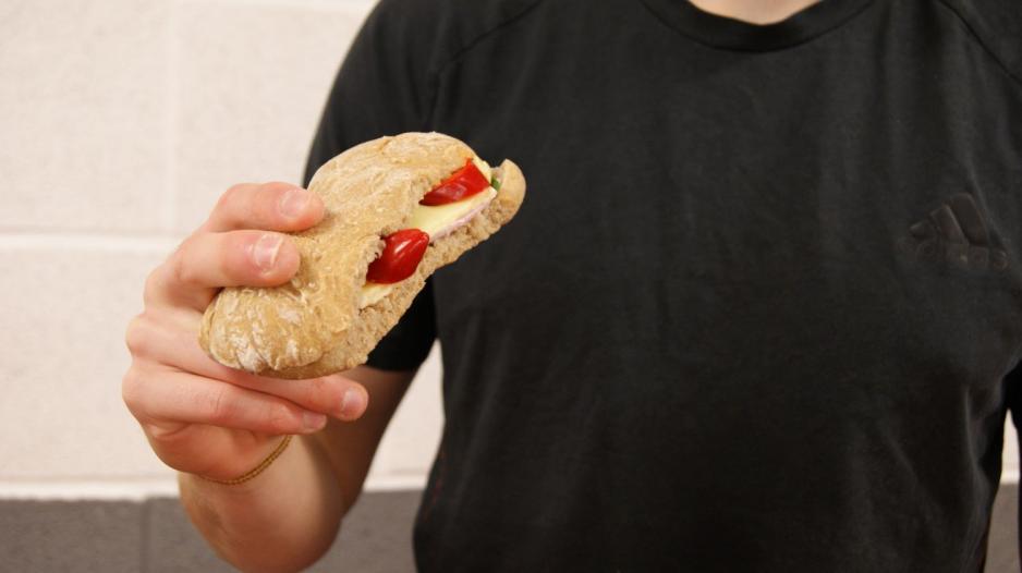 Et rundstykke med p&aring;legg holdes av en fyr.