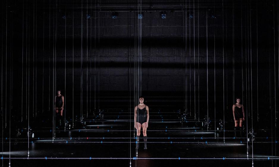 Tre dansere p&aring; en m&oslash;rk scene