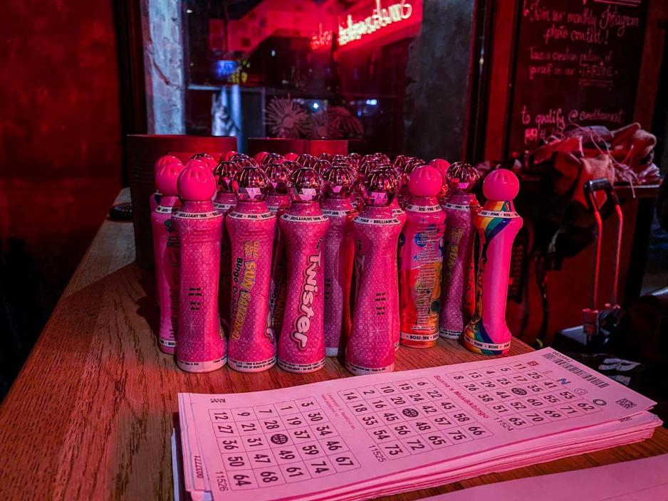 P&aring; bordet st&aring;r det flere rosa bingopenner. Ved siden av st&aring;r arkene med bingonummerne p&aring;. 