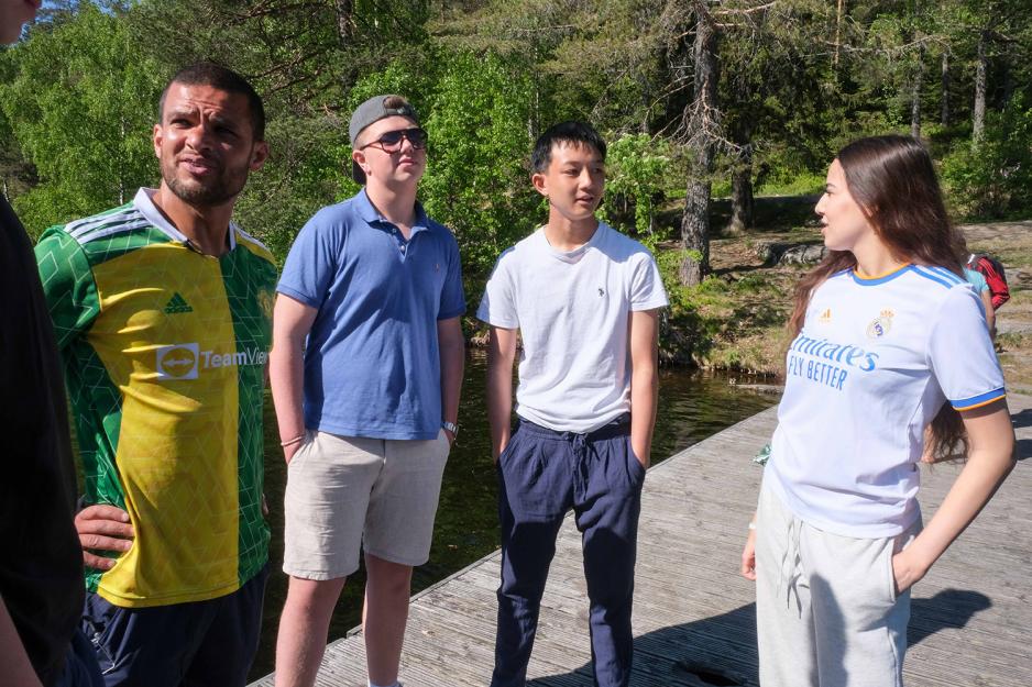 Gyml&aelig;rer Kamal st&aring;r p&aring; flytebrygga og prater med sine tre elever i sola. 