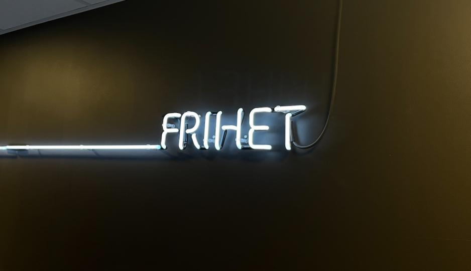 Neonskilt der det st&aring;r &laquo;Frihet&raquo; p&aring; sort vegg