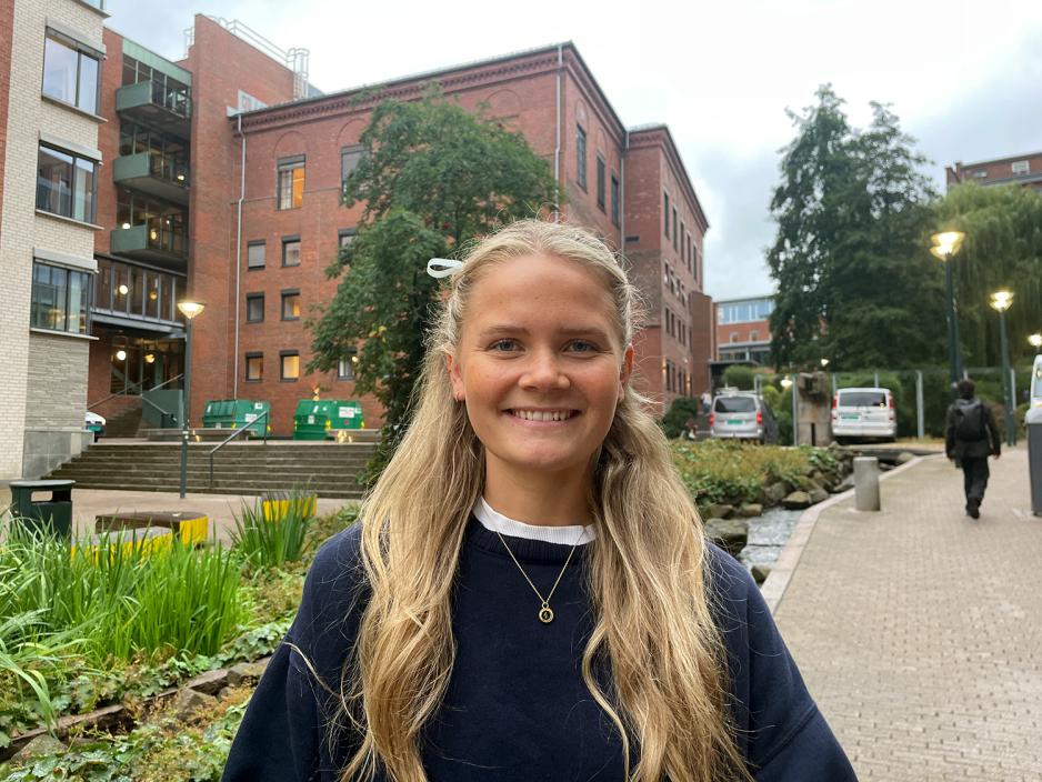 Kaia Olsen Lierstuen st&aring;r utenfor skolebygget der hun studerer.