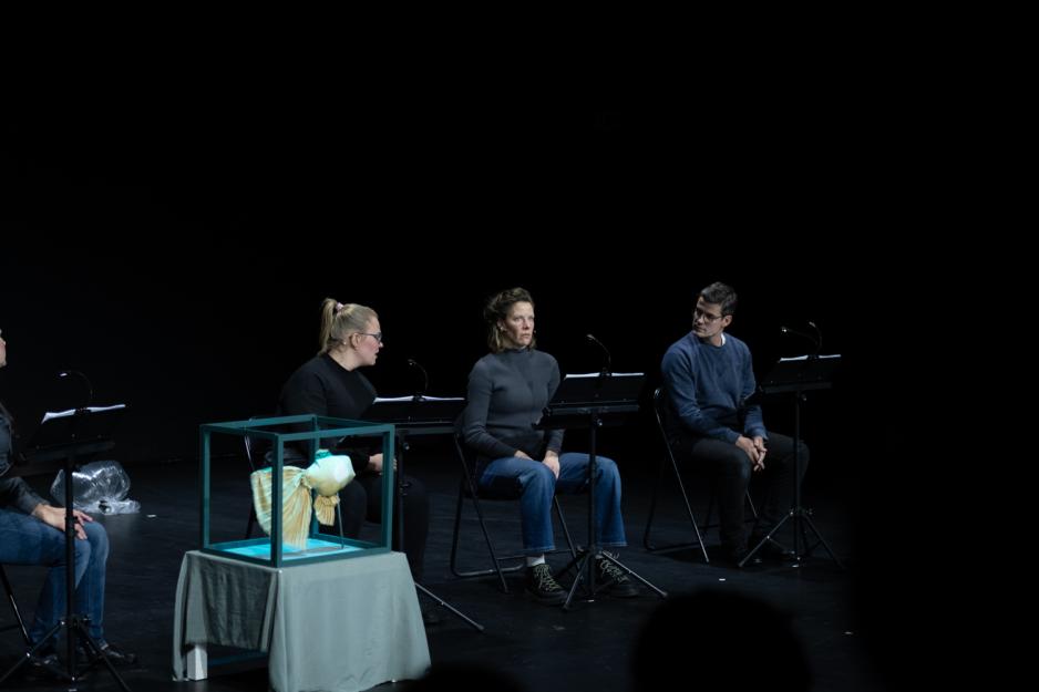 Skuespillere leser et stykke av Hannah Adolfsen Fjeldsbraathen p&aring; Vega Scene med en manet-dukke ved siden av seg. 