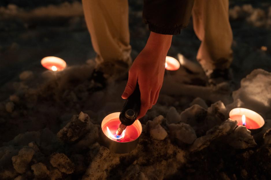 N&aelig;rbilde av hender som tenner p&aring; fakler i sneen