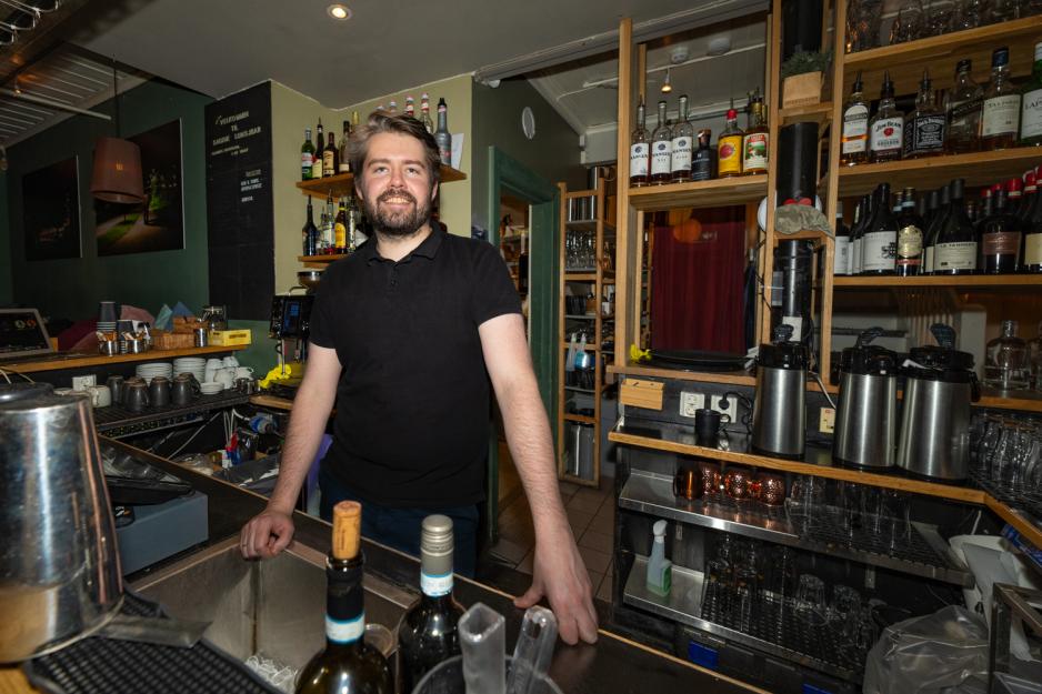Portrett av Audunn Sletvold som st&aring;r bak disken i baren