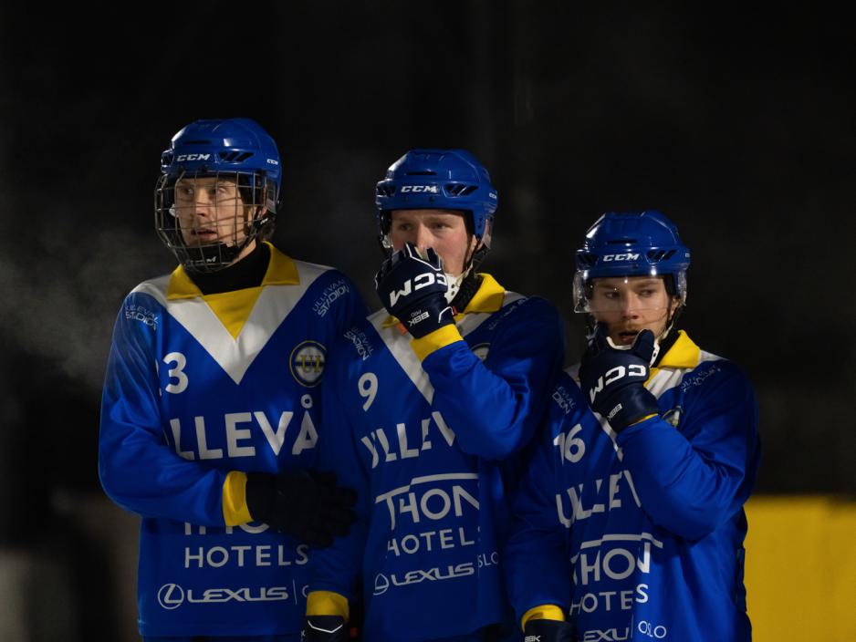 Tre bandyspillere st&aring;r sammen p&aring; isen