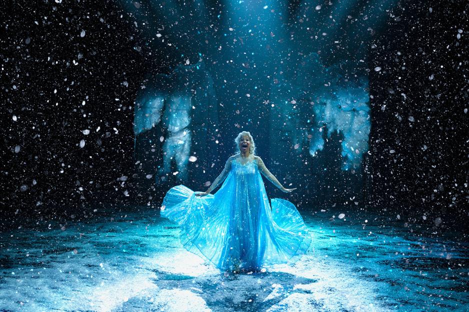 Jente i bl&aring; kjole synger p&aring; scenen