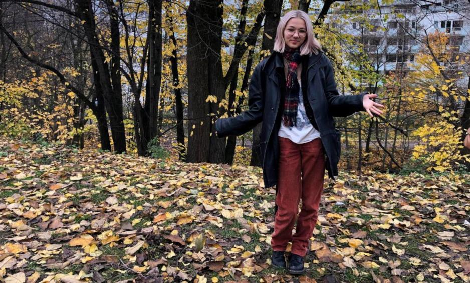 Elev st&aring;r i h&oslash;stlandskap, med gule blader og tr&aelig;r i bakgrunnen