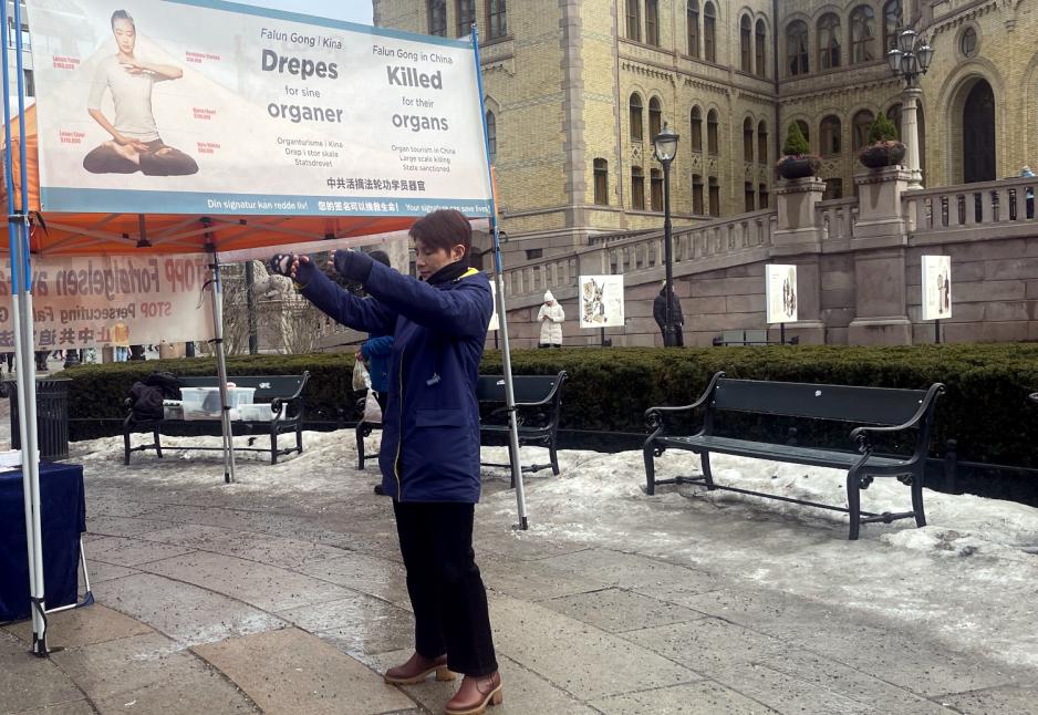 Kvinne viser fram ei Falun Gong-&oslash;ving