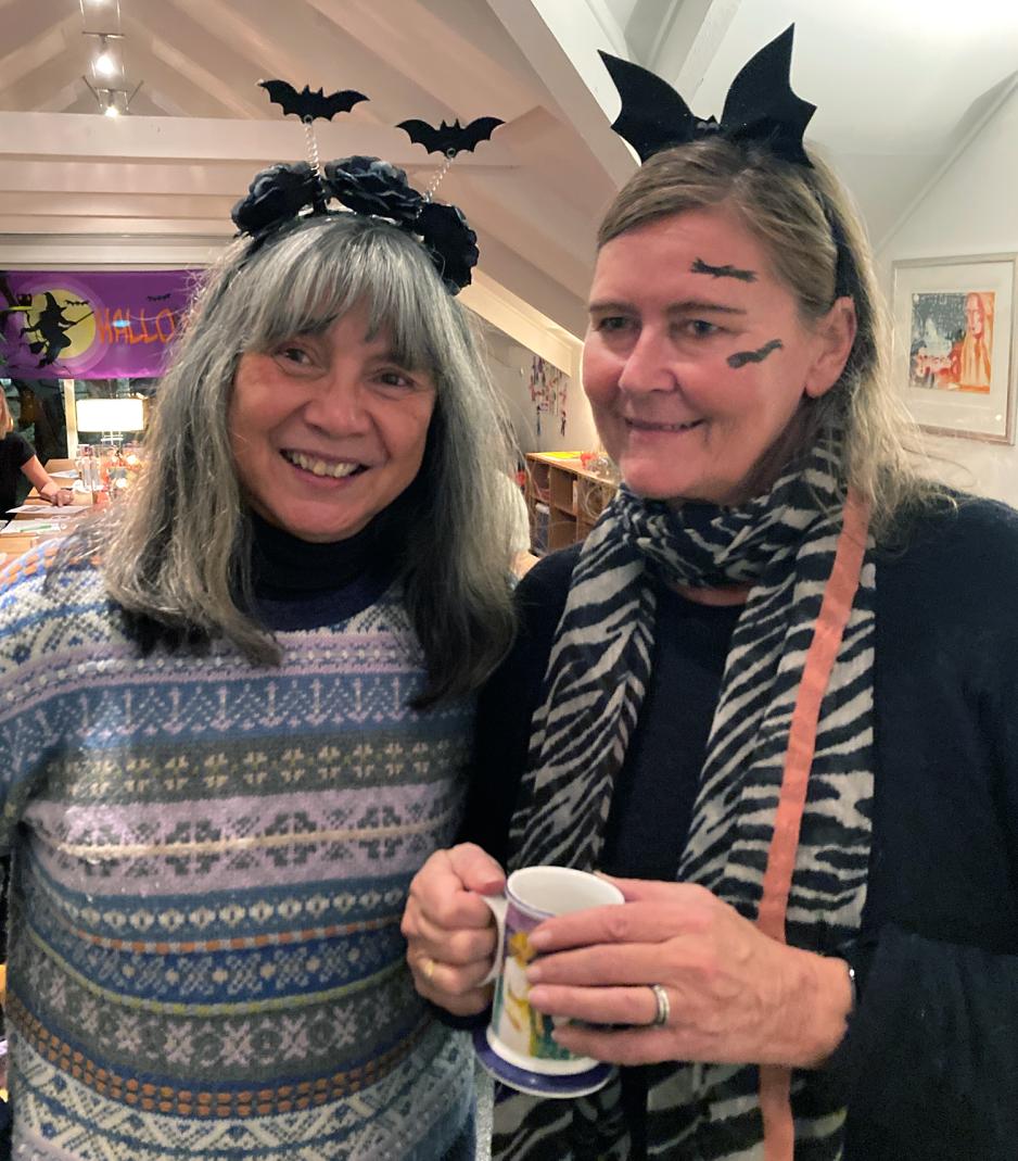 To damer smiler til kamera, med halloween-hatter p&aring; hodet, 