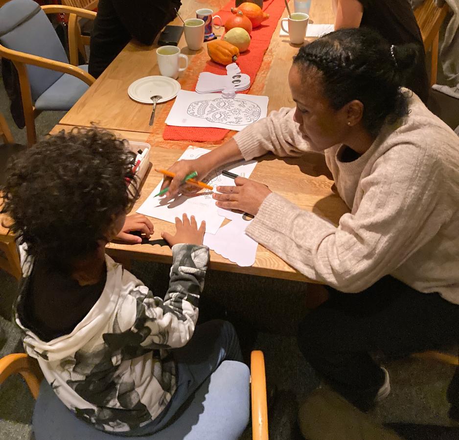 Mor og s&oslash;nn fargelegger en tegning av et gresskar sammen. 