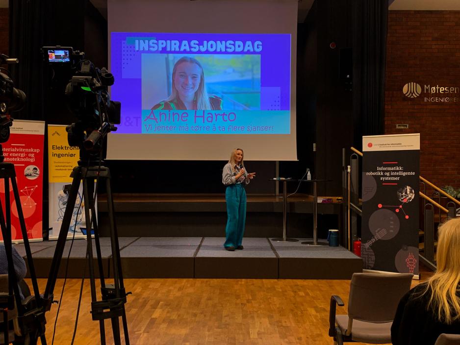 Anine Harto st&aring;r p&aring; scenen og holder foredrag