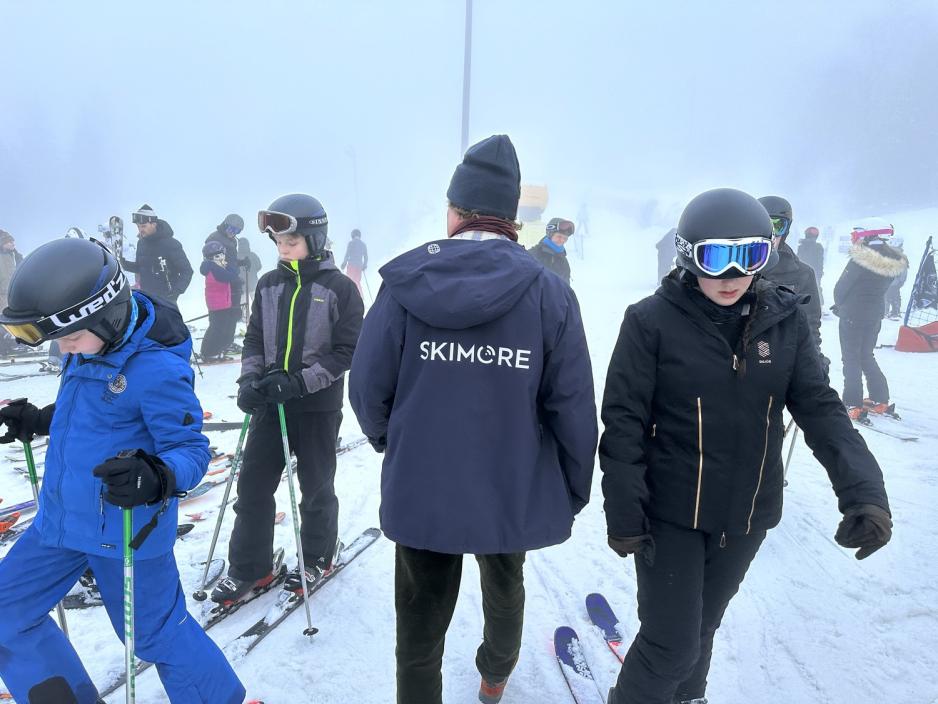Mann med folk rundt p&aring; skianlegg