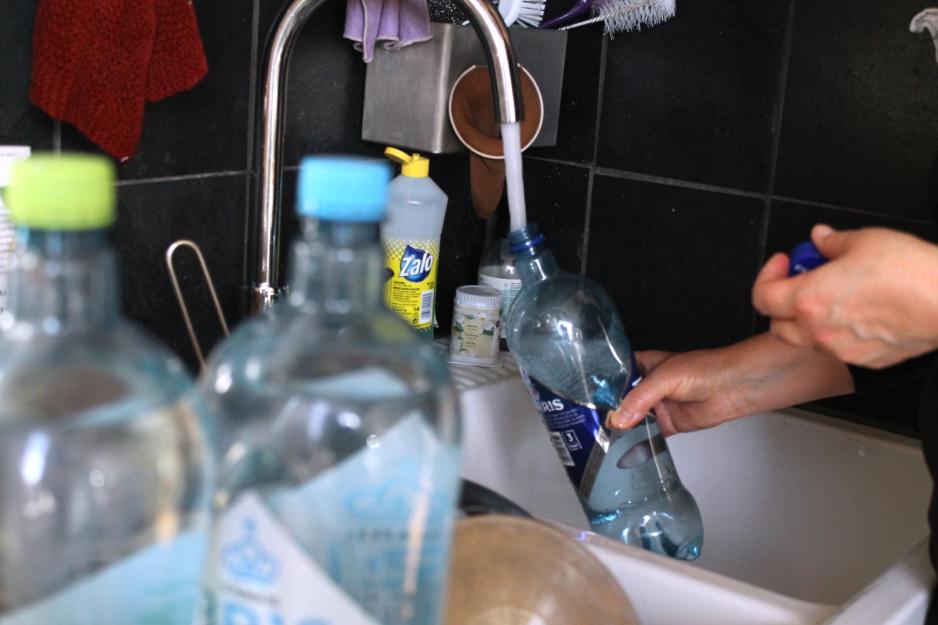 Vannflaske som fylles p&aring; i en vask p&aring; et kj&oslash;kken.