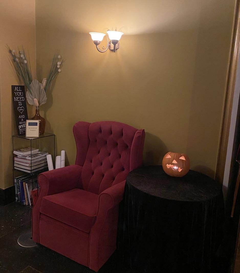 En r&oslash;d stol og et bord med et lysende gresskar