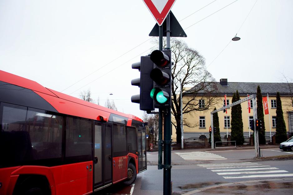 En buss kj&oslash;rer forbi n&aring;r tafikklyset blir gr&oslash;nt