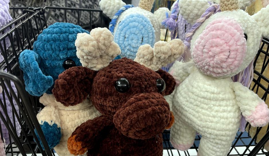 Bildet viser n&aelig;rbilde av heklede kosedyr med en elg i fokus. Disse er laget av "Hekle Per". 