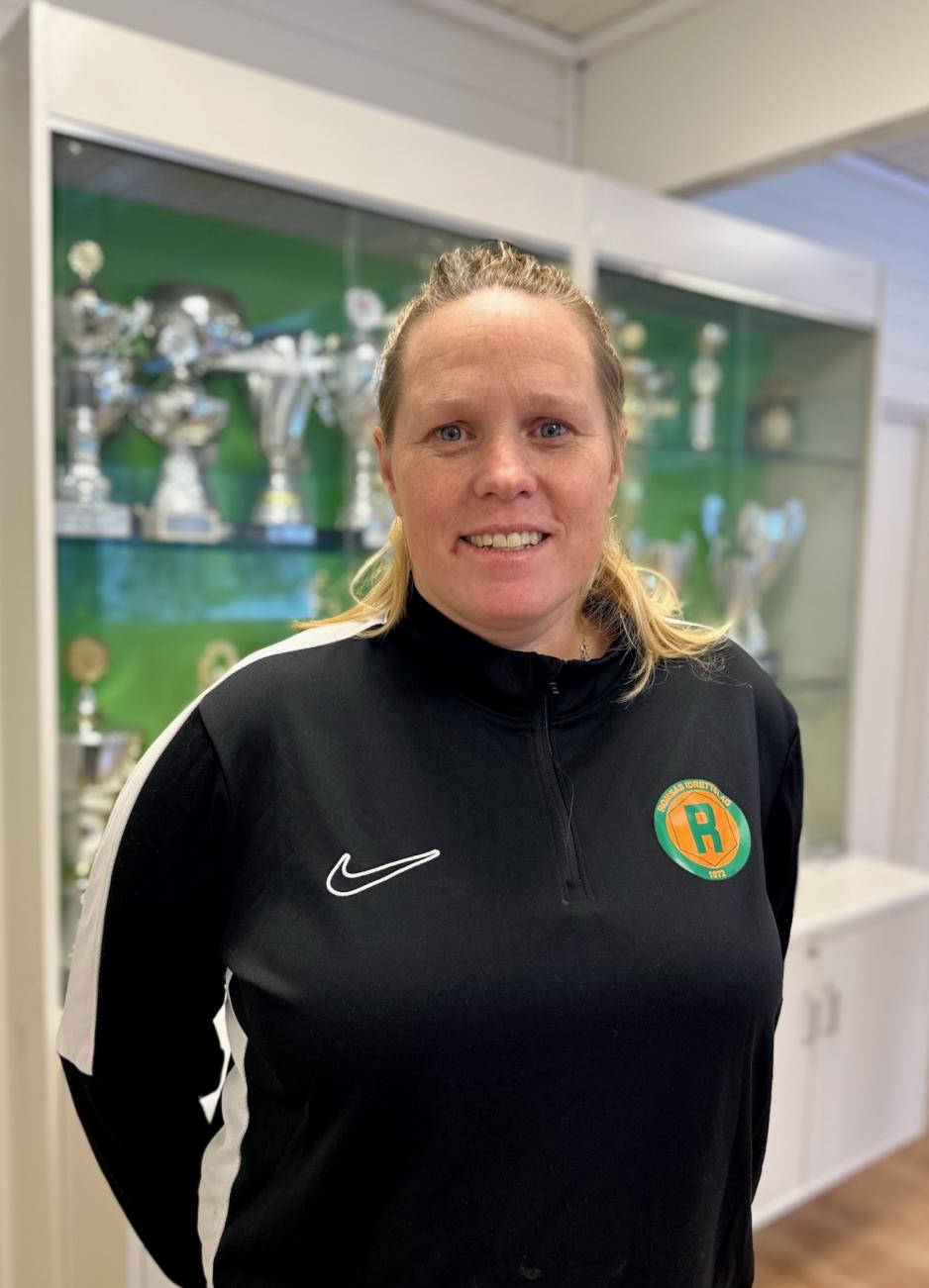 Marte Vik Edvardsen st&aring;r foran et glasskap med pokaler.