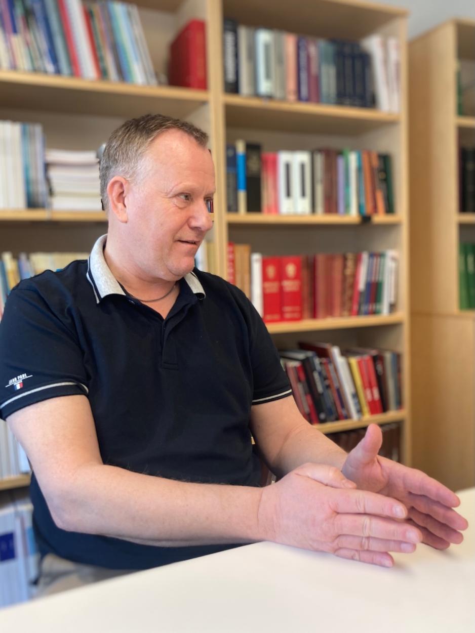 Mann som sitter ved et bord p&aring; et kontor