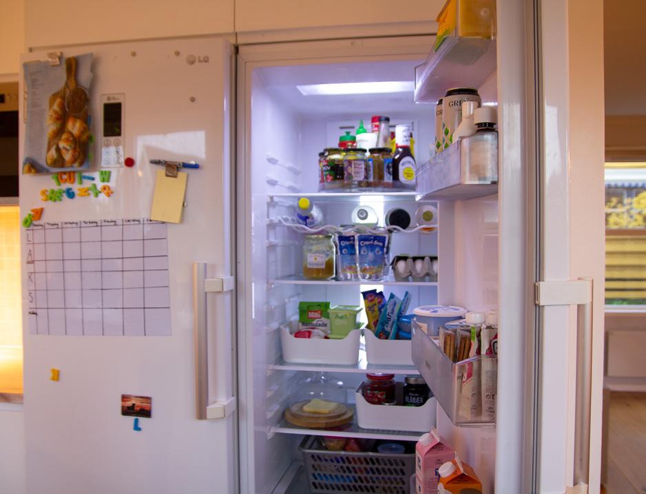 Et &aring;pent kj&oslash;leskap der mat og drikke er fordelt i organiserte bokser.
