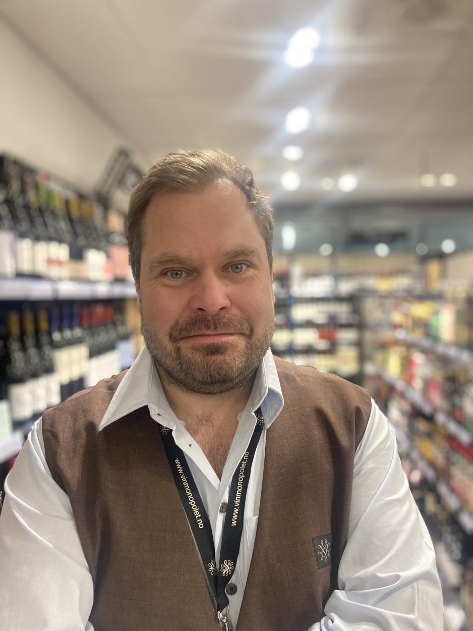 Mannlig ansatt p&aring; Vinmonopolet.