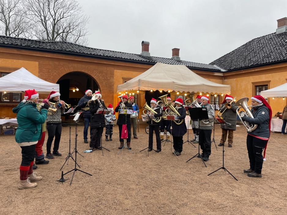 Bildet viser S&oslash;rkedalen Brass som er et brassband. 13 av bandets medlemmer er avbildet, og da bildet ble tatt spilte de julesanger. 