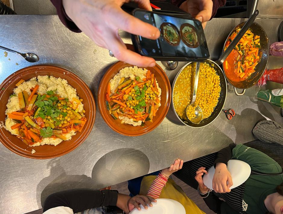 barna st&aring;r i k&oslash; og f&aring;r gr&oslash;nnsaker med couscous til middag, Foto Kiana Hassani