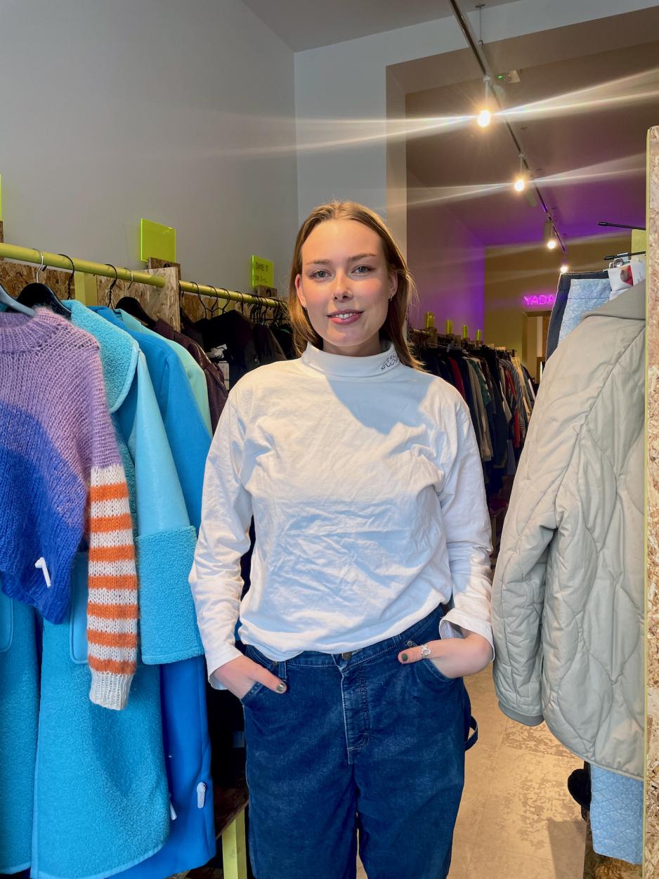 Deltidsansatt Marianne Instanes Mathiesen foran noen av kl&aelig;rne til butikken Rewear.