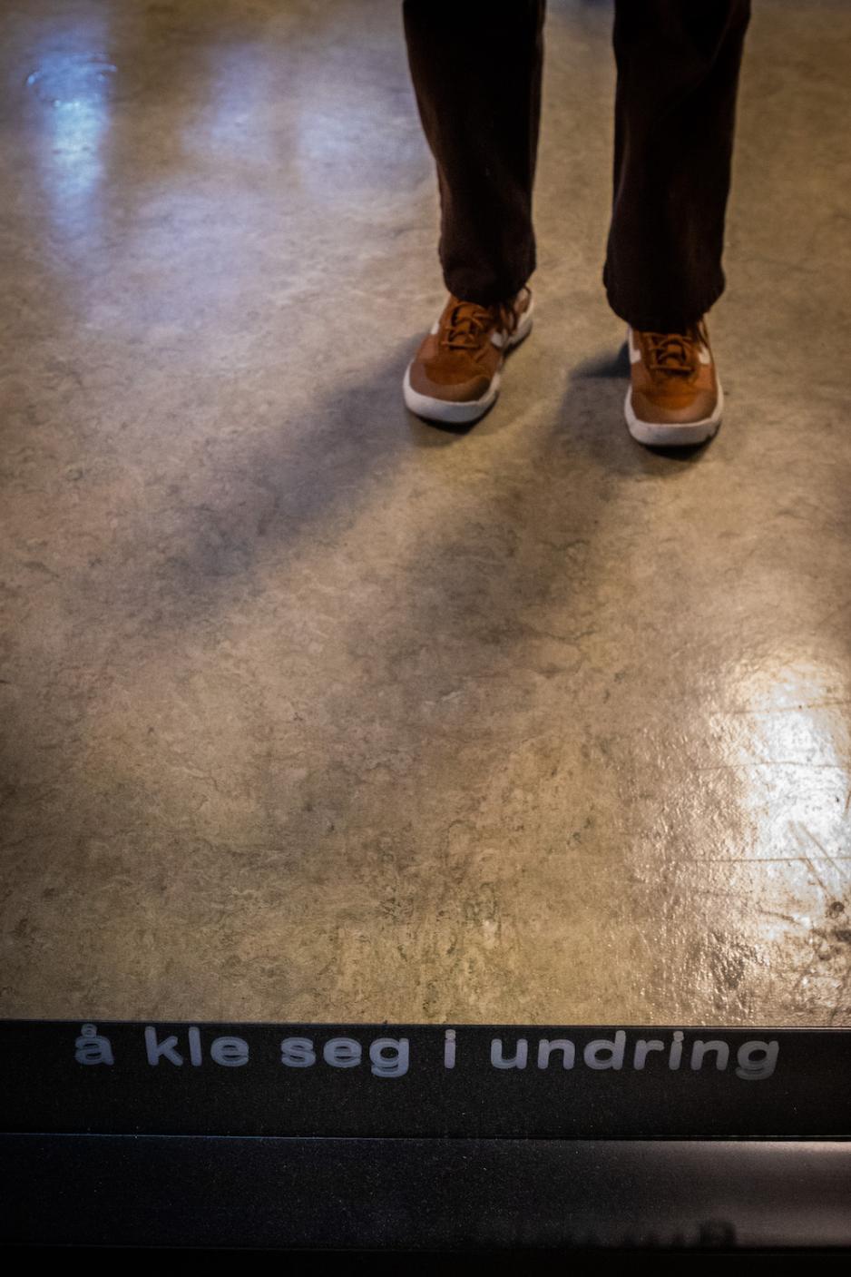 Tekst p&aring; et speil. Teksten er "&Aring; kle seg i undring".