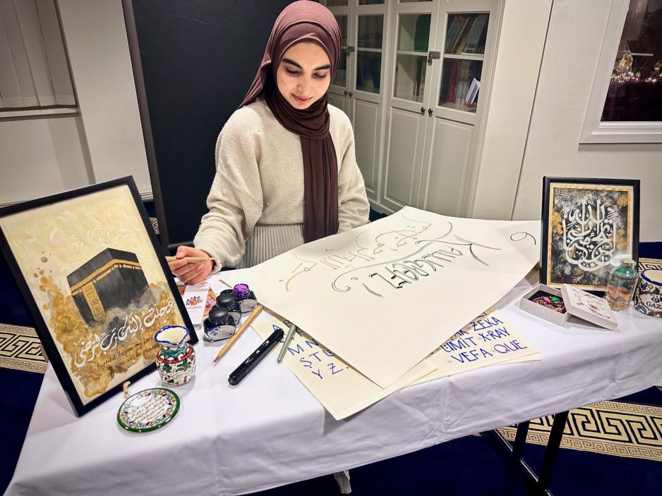 P&aring; kaligrafi standen jobbet en jente med &aring; lage en plakat.