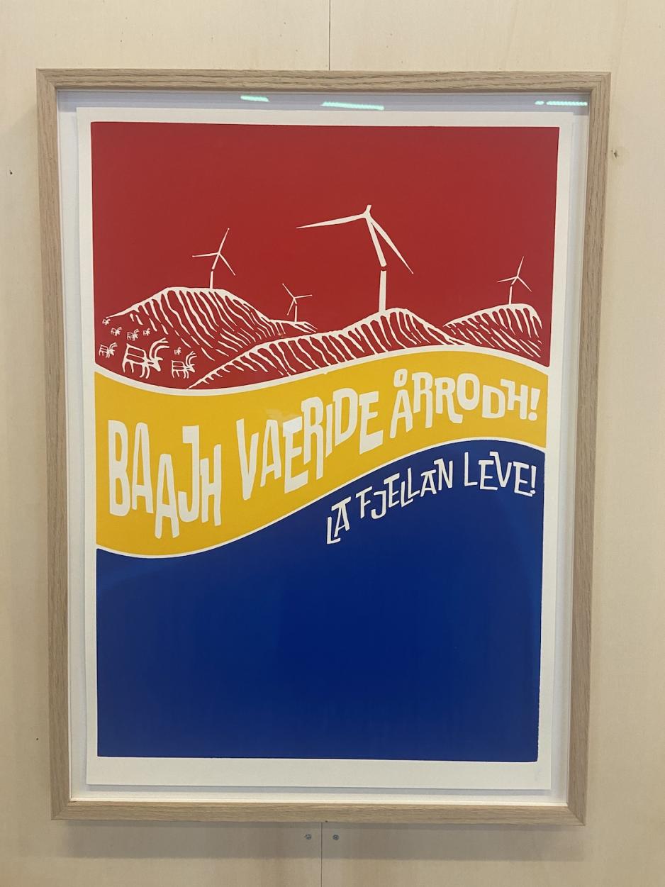 Kunstverk med gul, bl&aring;e og r&oslash;de farger som b&oslash;lger seg under et fjell med vindm&oslash;ller oppo