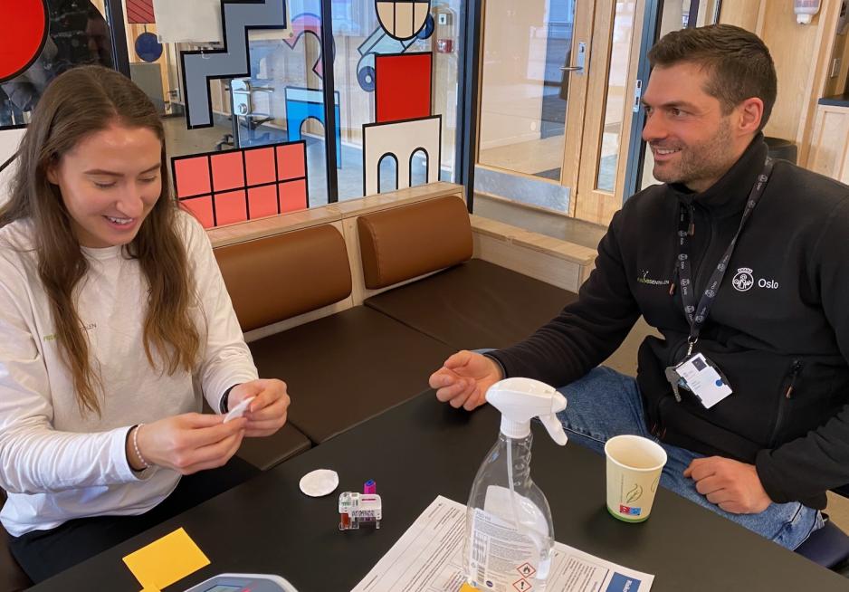 Kvinner m&aring;ler blodsukker p&aring; mann. De smiler i bildet, og han virker ikke nerv&oslash;s.